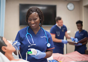 Photo of nursing students in scrubs inside the nursing lab