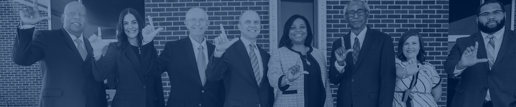 group photo of LU administration making L's with their thumb and forefingers