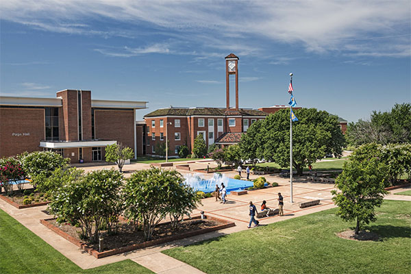 Photo of Langston University main campus facing the library clock tower and fountain area during daylight