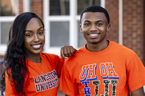 Photo of two students smiling in LU gear on campus grounds outside