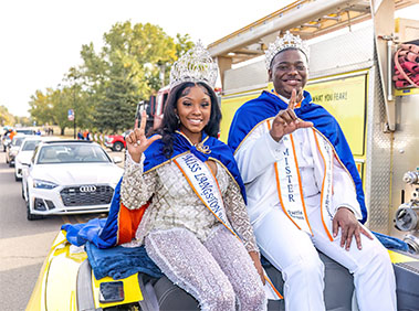 Mr and Miss Langston sitting in a convertible during homecoming parade
