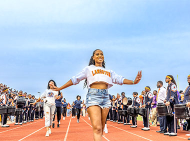Students strolling during homecoming on the track portion of he football field