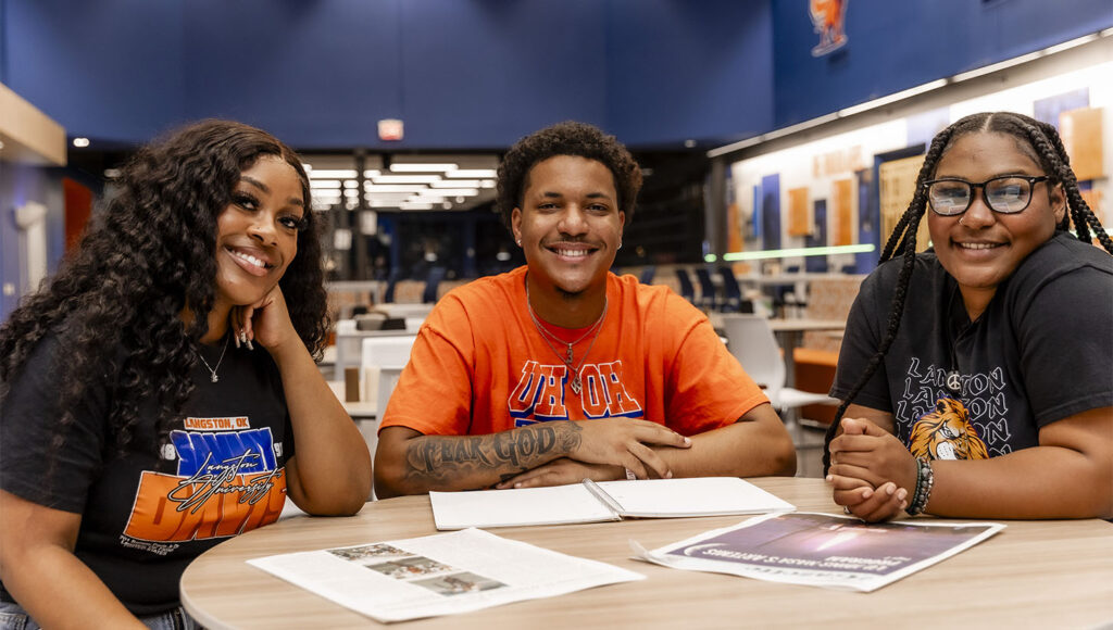 Photo of three students (two females and one male) seated at a table in the Student Success Center