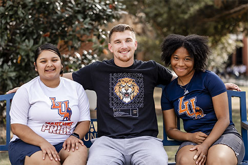 Photo of three students seated on bench on Langston University main campus