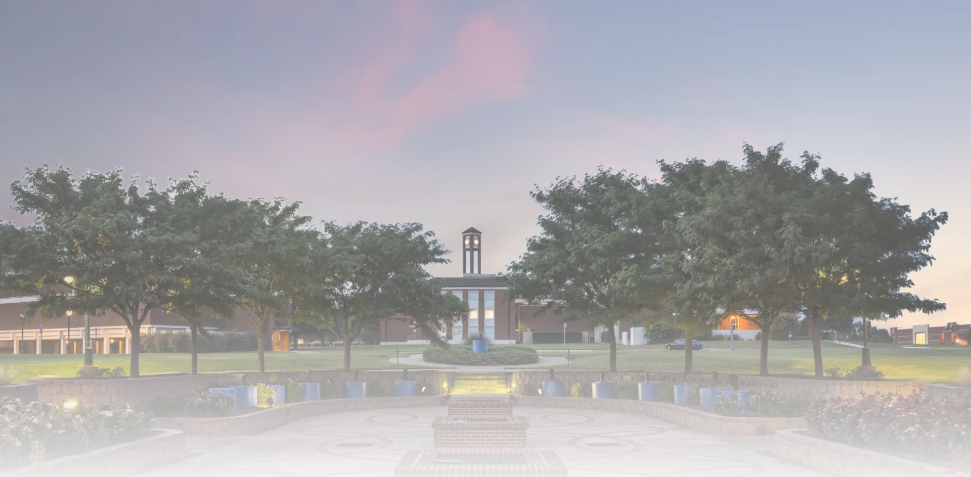 Image of campus at dusk facing the Library from where the Presidents' busts are located