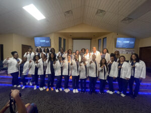 A group of students wearing white coats.