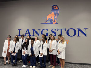 A group photo of students with white coats on.