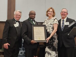 A photo of Dr. Clyde Montgomery receiving his award for being inducted into the Oklahoma Higher Education Hall of Fame