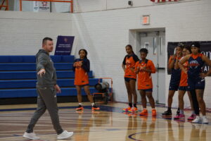 Coach Vincent points at a spot on the court during practice