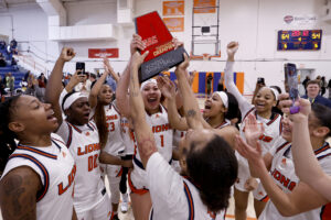 The Lady Lions basketball team hold us the SAC Conference Championship trophy