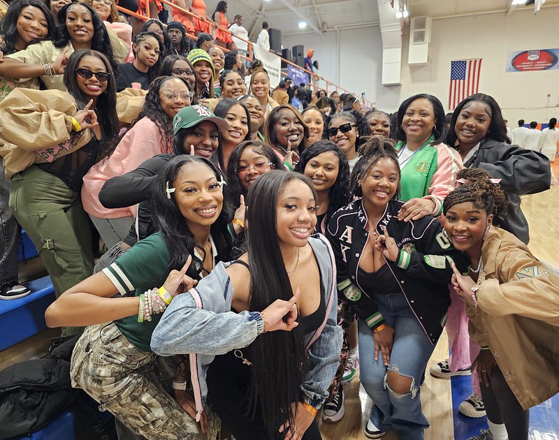 AKAs posing with LU President on sidelines at basketball game