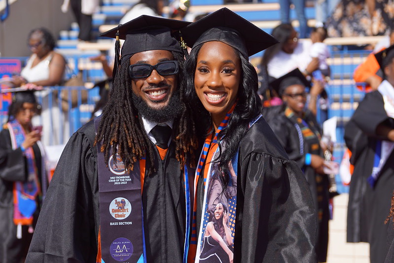 Two 2024 LU graduates smiling at commencement in regalia