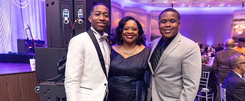 President Ruth Ray Jackson smiling in photo with two LU students during 19th annual gala