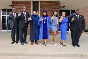 a group photo of faculty, alumni and students showing an "L's Up"