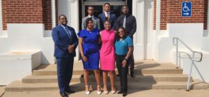 Code Blooded poses for a group photo in front of Moore Hall