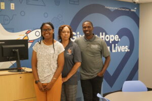 group poses in front of TDC mural