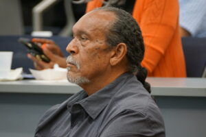 A photo of Dr. Herron sitting in an auditorium