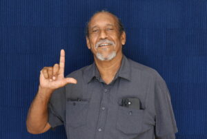Dr. Ruben Herron poses with his thumb and forefinger in an "L"