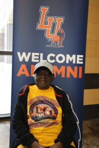 Ozetta Parker sits in front of a Langston University alumni banner