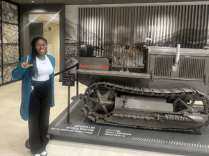 Emoree Coley poses next to an engine