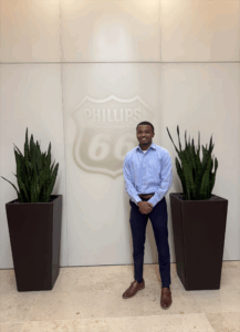 Reginald Archibald II poses next to a Phillips 66 sign.