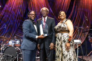 Dr. Ruth Ray Jackson and Dean Joshua Busby present Sherman Lewis with an award