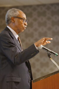 Sherman Lewis speaking at a podium