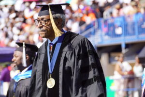 Sherman Lewis walking in academic regalia