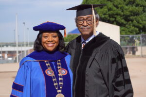 Sherman Lewis and Dr. Ruth Ray Jackson posing in academic regalia