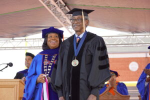 Dr. Ruth Ray Jackson preparing to hood Sherman Lewis at Commencement.