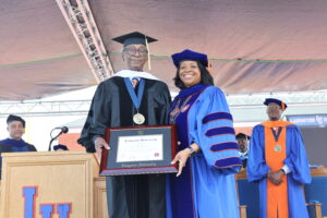 Dr. Ruth Ray Jackson presenting Sherman Lewis with an honorary doctorate.