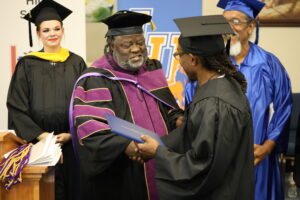 Sylvester Stanley shakes hands with Rehabilitation Services Professor Emmanuel Lewis.
