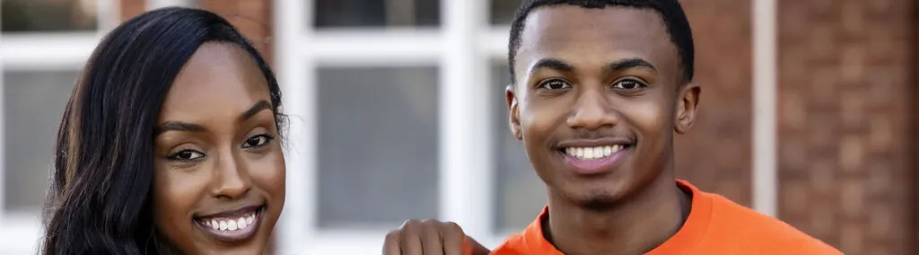 Photo of female and male student smiling on Langston University campus outdoors